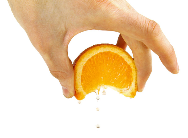 сжимать оранжевый в руке, изолированный на белом
 - Фото, изображение