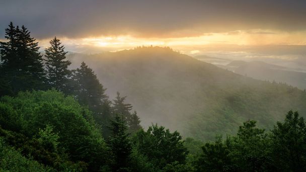 View of the Smokie Mountains from Blue Ridge Parkway with dramatic evening skies and fog rising from the valleys - Photo, Image