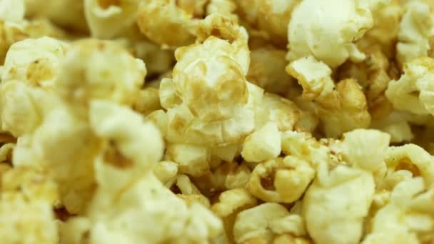 Lassú mozgás és pattogatott kukorica. Sárga friss sózott popcorn textúra kör forgatása közeli - Felvétel, videó