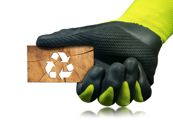 緑と黒の保護作業手袋を備えたマニュアルワーカーは,リサイクルシンボルで木片を保持しています. 白い背景に孤立した. 持続可能な資源コンセプト. - 写真・画像
