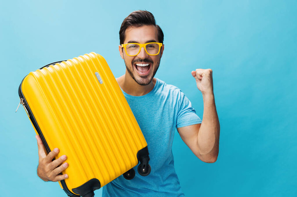 男幸せな旅行者コピーバックグラウンドフライトブルー週末旅行チケット旅行手荷物黄色のライフスタイルスタジオスーツケース旅行ヒップスター男休暇スペース - 写真・画像