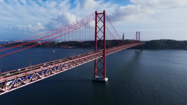 Letecký pohled na most Ponte 25 de Abril přes řeku Tagus v Lisabonu v Portugalsku za slunečného dne s nadýchanými mraky. Vysoce kvalitní 4K záběry - Záběry, video