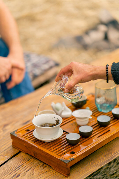 セレモニー中にふたが付いている特別な陶器のボウルで醸造されている天然の中国茶葉のクローズアップショット - 写真・画像