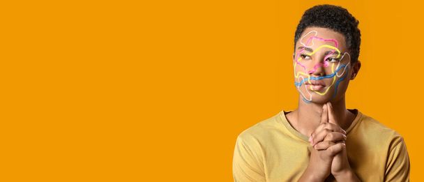Creative portrait of handsome African-American guy on orange background with space for text - Zdjęcie, obraz