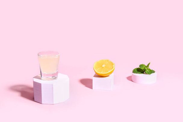 Декоративные подиумы с аппетитным лимончелло и мятой на розовом фоне - Фото, изображение