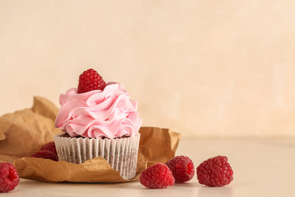 Вкусный малиновый кекс и свежие ягоды на бежевом фоне - Фото, изображение