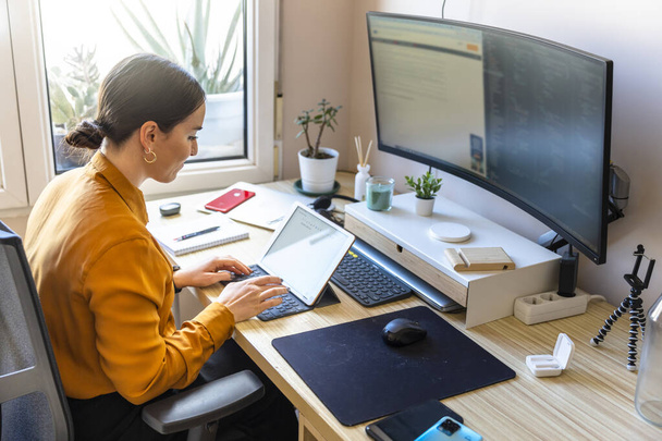 Programador informático trabajando desde casa. Concepto de teletrabajo. Mujer de negocios usando una tableta. - Foto, imagen