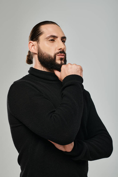 muotokuva mietteliäs arabialainen mies poolopaitaa koskettava parta ajatellessaan harmaa tausta - Valokuva, kuva
