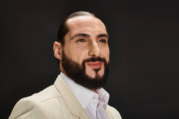 retrato de homem árabe barbudo alegre em camisa branca e blazer elegante posando no fundo preto - Foto, Imagem