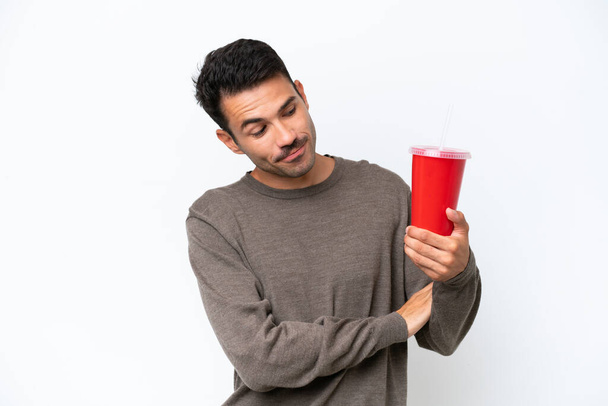 Young handsome man holding soda over isolated white background with sad expression - Photo, Image