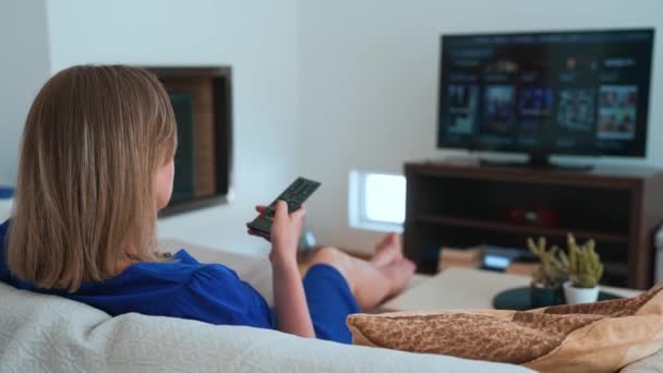 Žena sleduje obsah na své Smart TV doma. - Záběry, video
