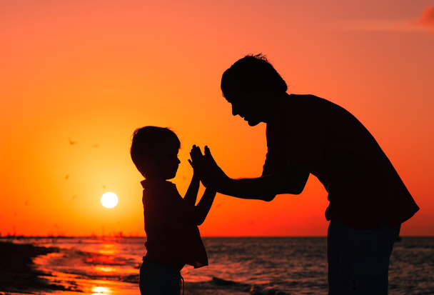 Отец и сын играют на закате
 - Фото, изображение