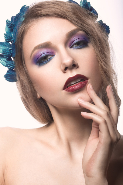 Beautiful blond girl with bright make-up and purple blue flowers in her hair. Beauty face. - Foto, imagen