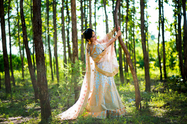Όμορφη ινδική νύφη σε παραδοσιακά ρούχα γάμου στο δάσος - Φωτογραφία, εικόνα