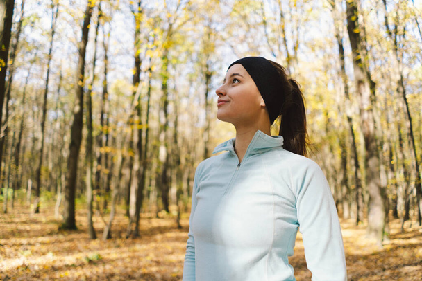 Beautiful girl doing fitness in nature on a sunny autumn forest. Body positive, sports for women, harmony, healthy lifestyle, self-love and wellness. - Photo, Image