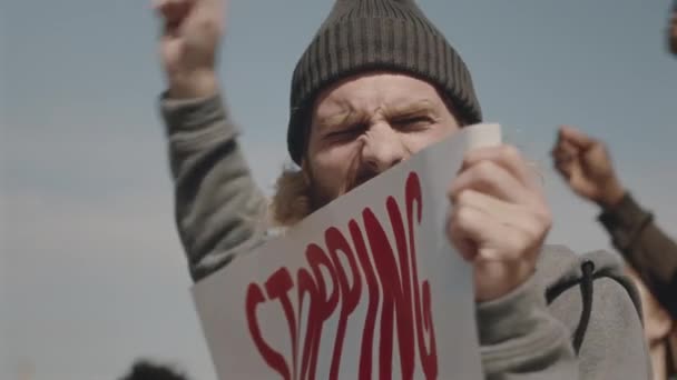 Junge emotionale Umweltaktivistin hält Plakat und skandiert Slogan auf Protest gegen Umweltverschmutzung - Filmmaterial, Video