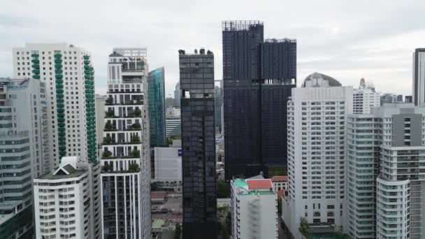 Letecký pohled na centrum města, budovy a mrakodrapy ve velkém městě během dne. Letící pozpátku do Bangkoku, letecký záběr. Filmová moderní metropole s mrakodrapy Bangkok, Thajsko - 2. září 2023 - Záběry, video