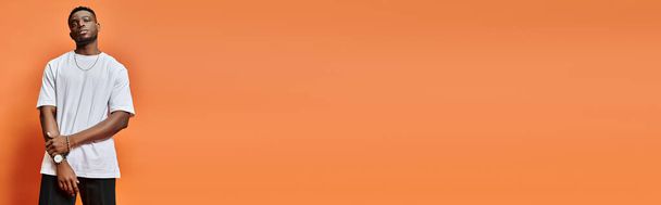 красивый африканский американец в уличной повседневной одежде на оранжевом фоне, концепция моды, баннер - Фото, изображение