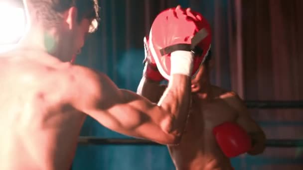 アジア人と白人ムエタイのボクサーは激しいボクシングトレーニングセッションでパンチを放つ、スパーリングトレーナーにパンチストライキを提供し、ムエタイのボクシング技術とスキルを紹介します。インペトゥス - 映像、動画