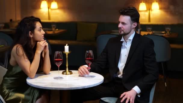 Šťastný milující muž a žena sedí v moderní restauraci, mluví a těší víno. Životní styl, láska, pojetí vztahů. Video v reálném čase. - Záběry, video