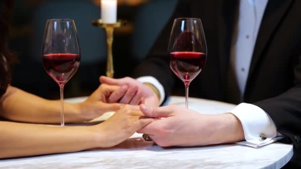 Mies pitää naisen kädet kun ottaa romanttinen päivämäärä ravintolassa, rajattu, lähikuva. Elämäntapa, rakkaus, ihmissuhteet. Reaaliaikainen video. - Materiaali, video
