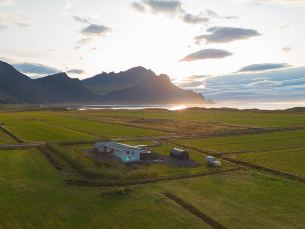 Bovenaanzicht vanuit de lucht op huizen of hotels met bergen in IJsland eilanden in het zomerseizoen, Europa heuvels, natuur landschap achtergrond. - Foto, afbeelding