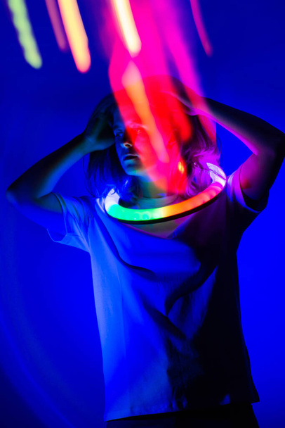 Blonde woman model  dancing  on the stage in multicolored background in neon light. Young beautiful elegant girl  dancing  on the stage in neon glowing  texture.  - Photo, Image
