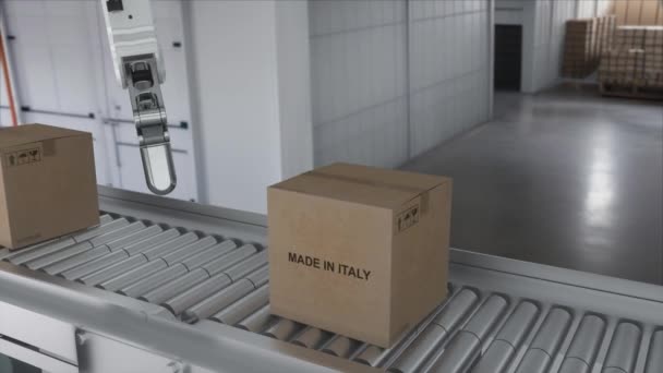 Robotí rameno zvedne lepenkovou krabici vyrobenou v ITÁLIE. Kartónové krabice s výrobkem od ITÁLIE na válečkovém dopravníku. - Záběry, video