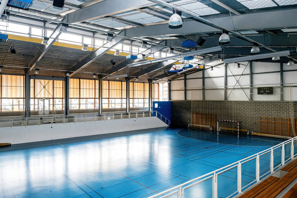 Μια ευρύχωρη πανεπιστημιακή αθλητική αίθουσα, που διαθέτει μίνι ποδόσφαιρο στόχους και ένα καθαρό εσωτερικό, είναι έτοιμη να φιλοξενήσει μια ποικιλία από αθλητικά έργα - Φωτογραφία, εικόνα