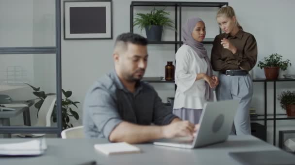 Selektive Fokusaufnahme einer ignoranten jungen Frau, die neben ihrem Kollegen steht und Klatsch und Tratsch verbreitet oder ihren Kollegen aus dem Nahen Osten diffamiert - Filmmaterial, Video