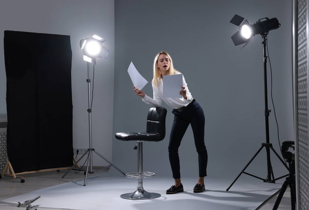Casting call. Emotional woman performing against grey background in studio - Φωτογραφία, εικόνα
