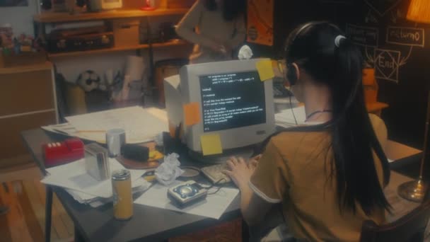Joven programadora femenina trabajando en código cuando sus compañeros de trabajo masculinos comienzan a jugar al juego de batalla de bolas de papel - Imágenes, Vídeo