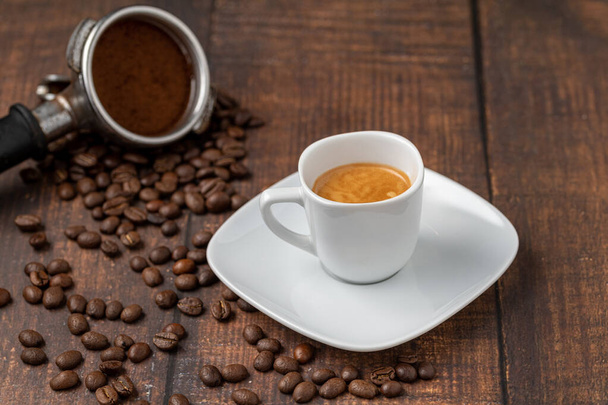 Tuore espressokahvi yhdessä koristeltu kahvipavuilla puupöydällä - Valokuva, kuva