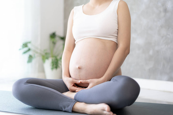 Mulher grávida fazendo Yoga no tapete de exercício. meditação para o parto a termo de meditação atraente Gravidez recreação feminina e relaxar, respiração e calma com ioga. Autocuidado - Foto, Imagem