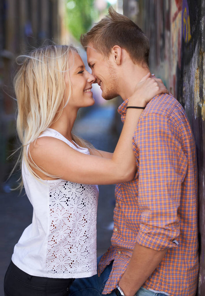 Love, city and couple hug on road for date, cute relationship and bonding outdoors on weekend. Dating, romance and happy man and woman embrace for flirting, connection and adventure in urban town. - Photo, Image