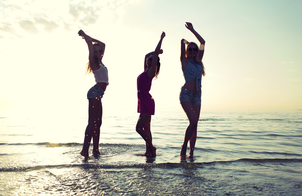 felices amigas bailando en la playa
 - Foto, imagen
