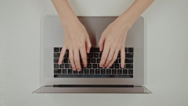 Widok z góry młodej kobiety zajętej pracą nad laptopem lub klawiaturą komputerową, aby wysłać zapytanie do sieci neuronowej czatbota AI, surfowanie w przeglądarce internetowej, sztuczna inteligencja, badania - Materiał filmowy, wideo