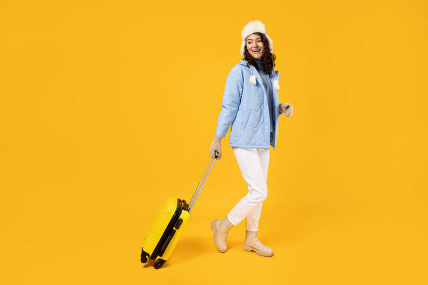 Bavullu, sıcak kayak takımı giymiş bir kadın.. - Fotoğraf, Görsel
