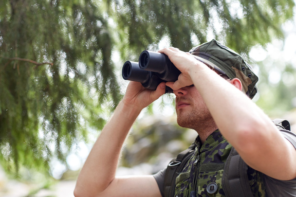 joven soldado o cazador con binocular en el bosque
 - Foto, Imagen