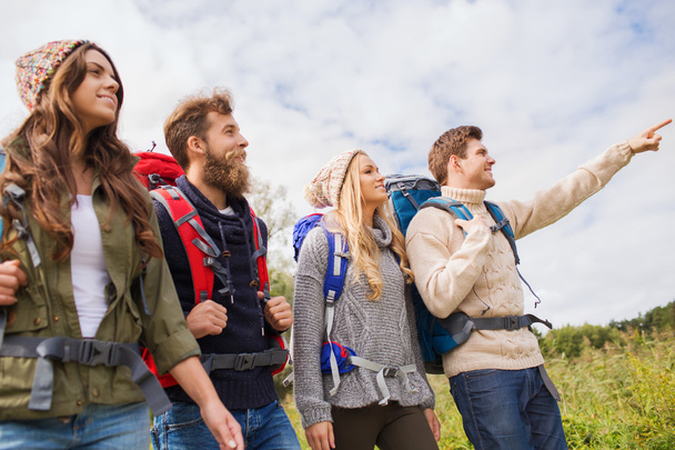 group of smiling friends with backpacks hiking - Fotografie, Obrázek