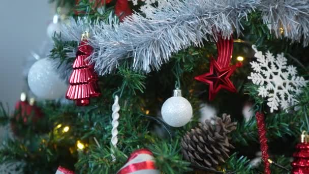 Díszített ünnepi elemek, egy ünnepi karácsonyi labdák és hópelyhek lógnak a fa buja zöld ágak, létrehozva egy gyönyörű Xmas dekoráció. - Felvétel, videó