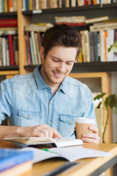 happy student reading book and drinking coffee - Фото, зображення