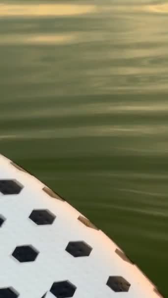 supboard en el agua cerca de la puesta del sol por encima del espacio de copia del lago - Imágenes, Vídeo