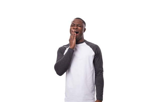 young positive african man dressed in a spring jacket on a white background with copy space. - Photo, Image