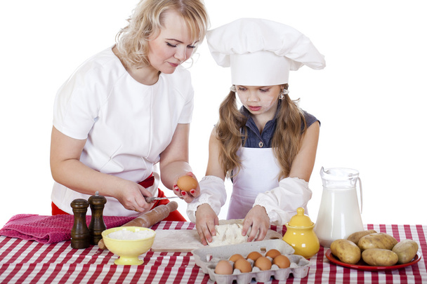 Little girl helping her mother prepare a cake - Photo, image