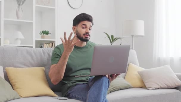 Af en toe gekleed hindoe man zich verdrietig van mislukking tijdens het werken aan moderne laptop thuis. baard jong guy aanraken voorhoofd en het hebben van stress tijdens remote job ervaring. - Video