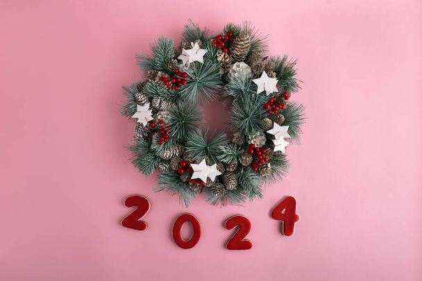 Corona de Navidad y 2024 Año nuevo de pan de jengibre sobre fondo rosa. Feliz Año Nuevo 2024. - Foto, imagen