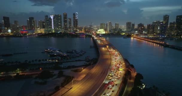 Congestione del traffico causata da un incidente stradale nel centro della città americana su un ampio ponte autostradale a Miami, Florida di notte. Edifici grattacieli sulle infrastrutture di trasporto urbano - Filmati, video
