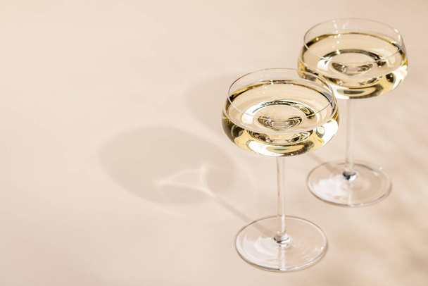 Dos copas de champán sobre fondo beige con espacio para copiar - Foto, imagen