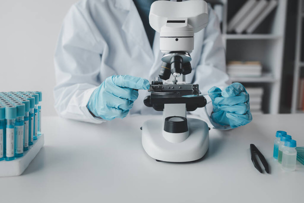 kemisti tekee koetta laboratoriossa, tiedemies käyttää mikroskooppia kemiallisen koostumuksen analysointiin, tieteellinen kokeilu etsii biologisia vastauksia laboratoriossa. - Valokuva, kuva
